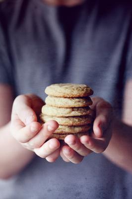 A close shot of a baker presenting a stack of sugar cookies