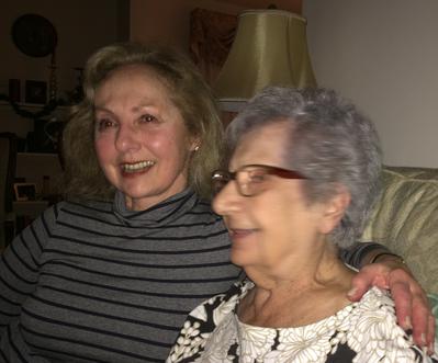 Two women sitting on a couch in a living room.