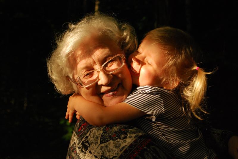 An elderly aging woman and child sharing a loving hug