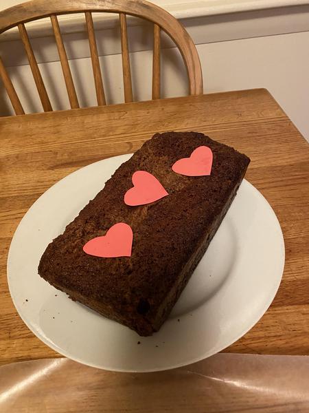 A home-made baked good rests on a saucer on a kitchen table